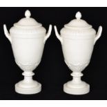 A pair of 20th Century Berlin blanc de chine twin handled pedestal vase and covers,