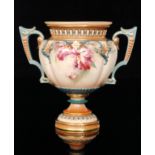 A late 19th Century Hadley's Worcester twin handled pedestal vase decorated with body with hand