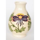 A Moorcroft Pottery baluster vase decorated in the Columbine pattern with tubelined flowers and