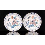 A pair of late 18th Century Delft tin glazed chargers each decorated with a large manganese flower