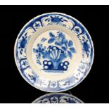 An early 19th Century Delft plate decorated in the typical manner with flowers and foliage,