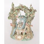 A Francis Berrisford studio pottery mythical tableau model of a dragon reading sat upright in a