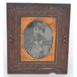 A Victorian ambrotype photograph of a seated lady in a black dress in an embossed vulcanite frame,