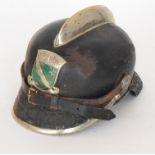 A pre World War Two German black leather fire helmet mounted with a green painted Prussian badge,