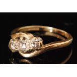 An 18ct diamond three stone ring, claw set stones to a slight twist, ring size L 1/2.