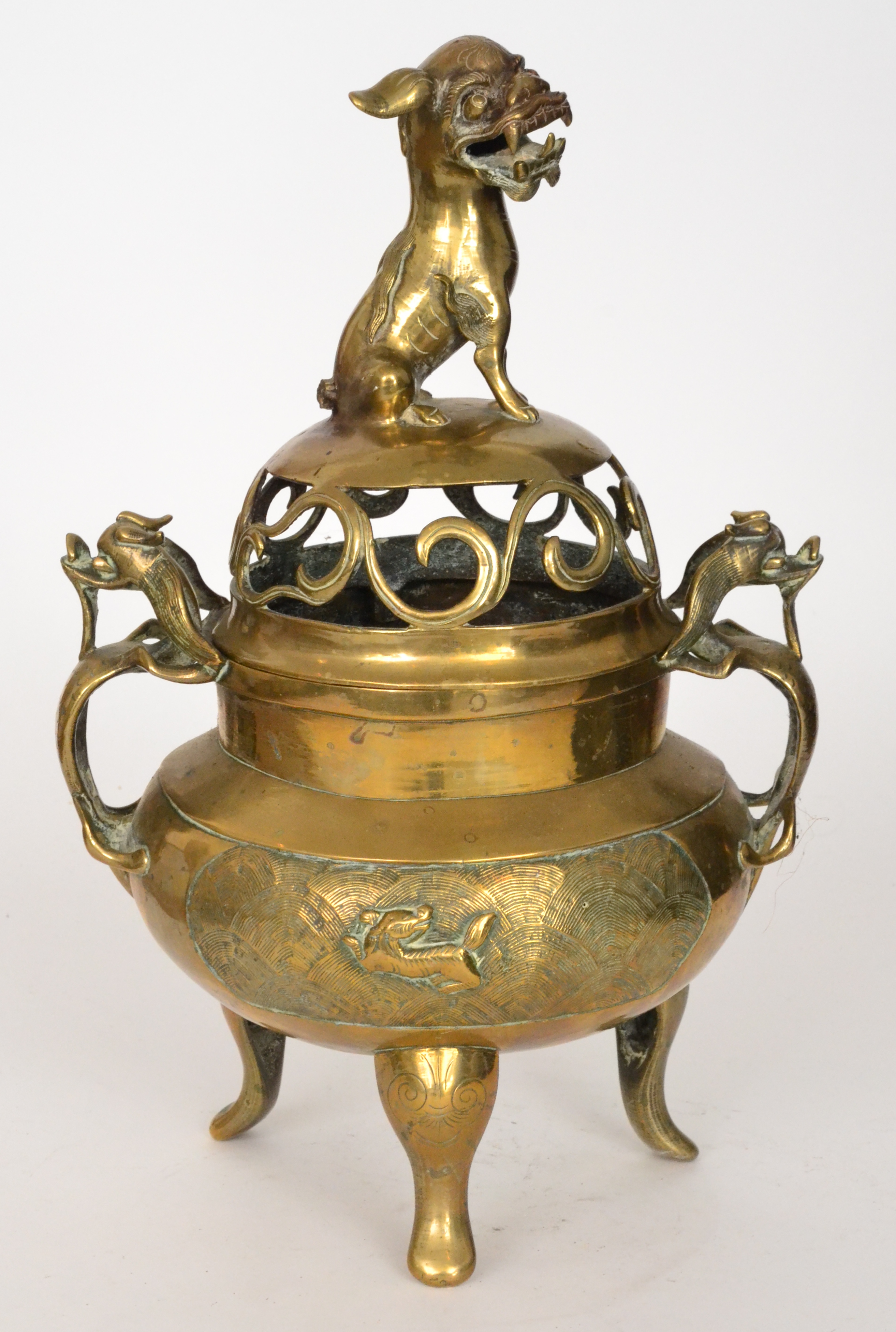 A 20th Century Chinese brass koro with pierced cover mounted with a Manchu dog over two dragon