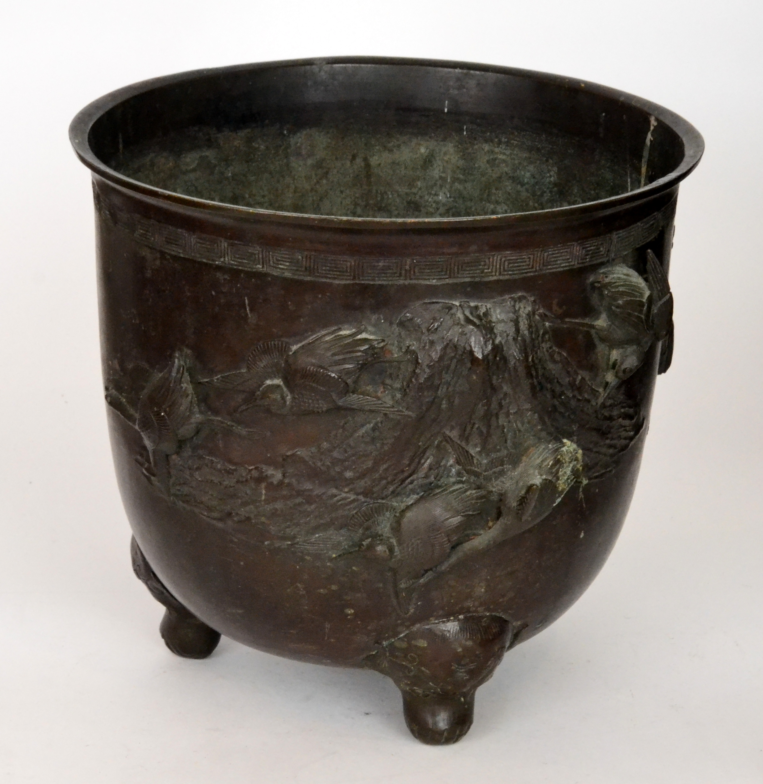 A late 19th Century Japanese bronze jardiniere applied with birds in flight, on three shaped feet,