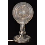 A mid 20th Century cut glass table lamp with circular ribbed globe formed shade on a fluted turned