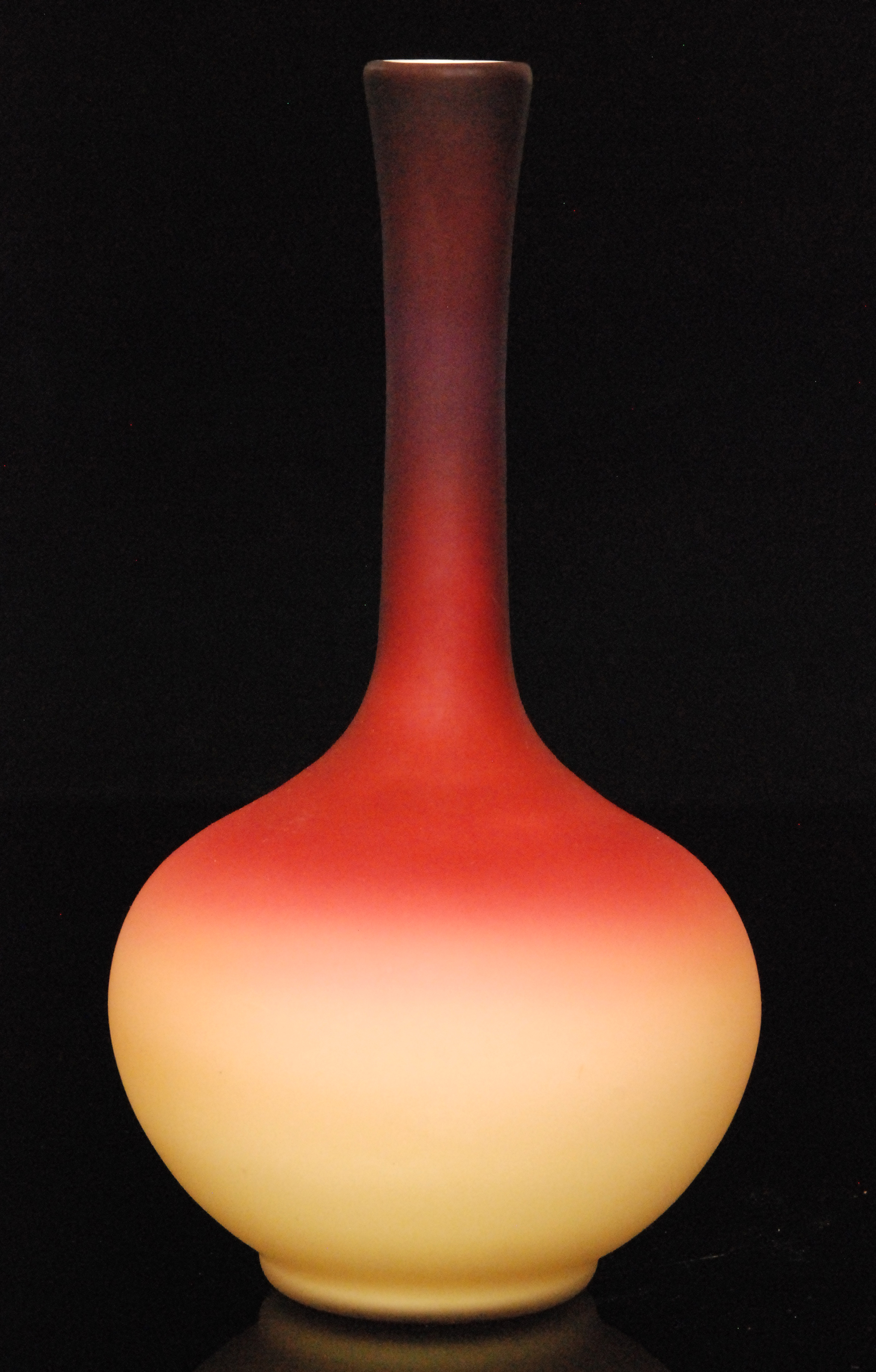 A late 19th Century Wheeling glass vase of globe and shaft form decorated with a dye away ruby to