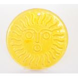 A Whitefriars glass sun catcher of circular form with stylised sun mask face design to the yellow