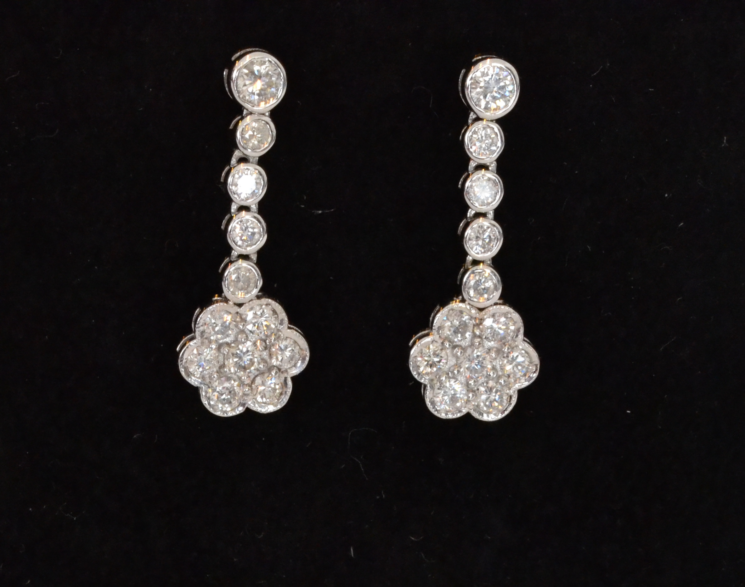 A pair of 18ct white gold diamond daisy drop earrings,