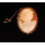 A late 20th Century oval cameo of a maiden in profile within 9ct mount with rope twist and scroll