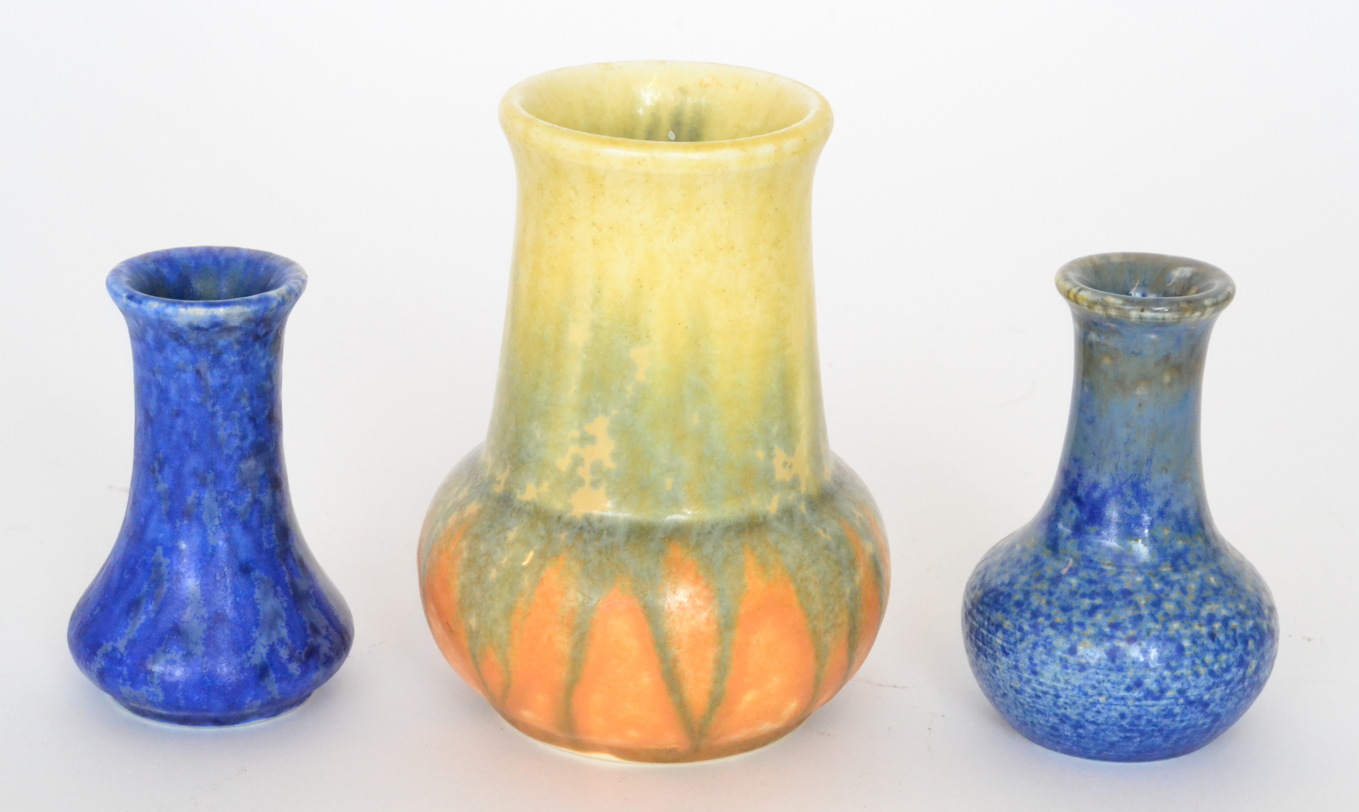 Three Ruskin Pottery vases comprising a mottled blue bud vase, height 7.