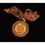 A 1982 half sovereign within circular pierced pendant mount with rope twist border,