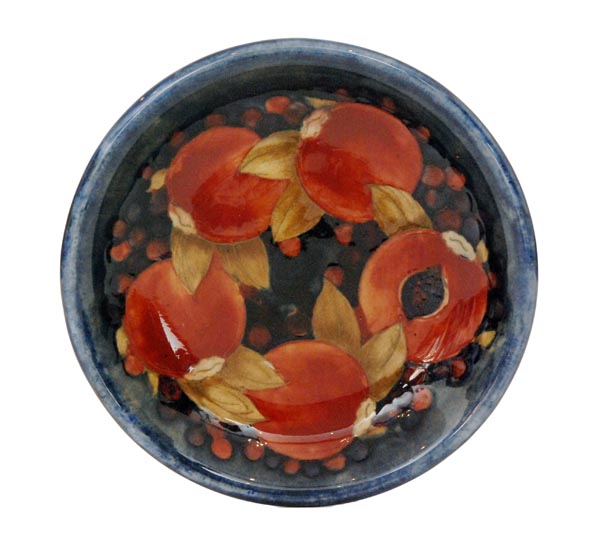 A William Moorcroft Pomegranate pattern shallow dish decorated with four whole and one open fruit