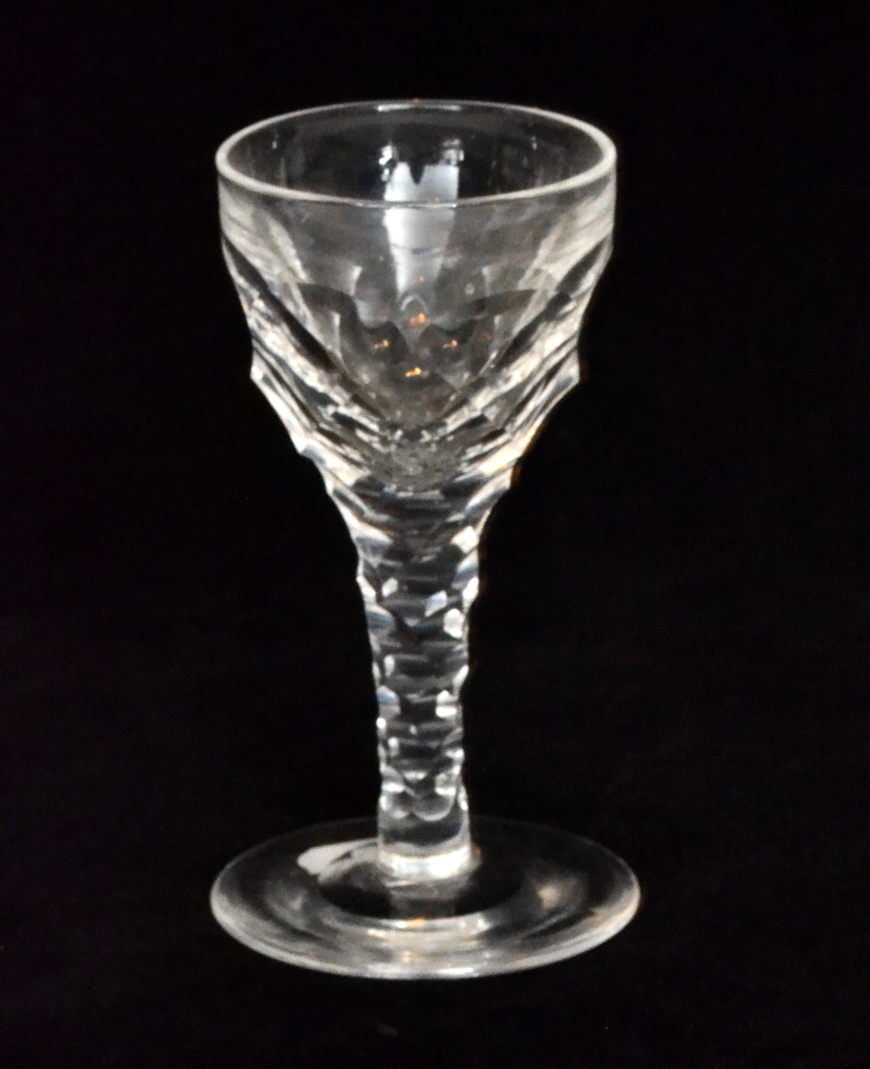 A 19th Century drinking glass in the 18th Century taste with a facet cut bowl falling to a facet
