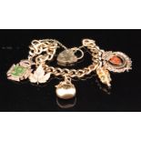 A 9ct filed curb bracelet terminating in padlock fastener with five 9ct charms attached,