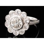 An 18ct hallmarked white gold diamond daisy cluster ring, central brilliant cut stone weight 1.