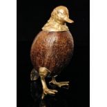 A 20th Century worked and brass mounted coconut inkstand in the form of a duck with webbed feet and