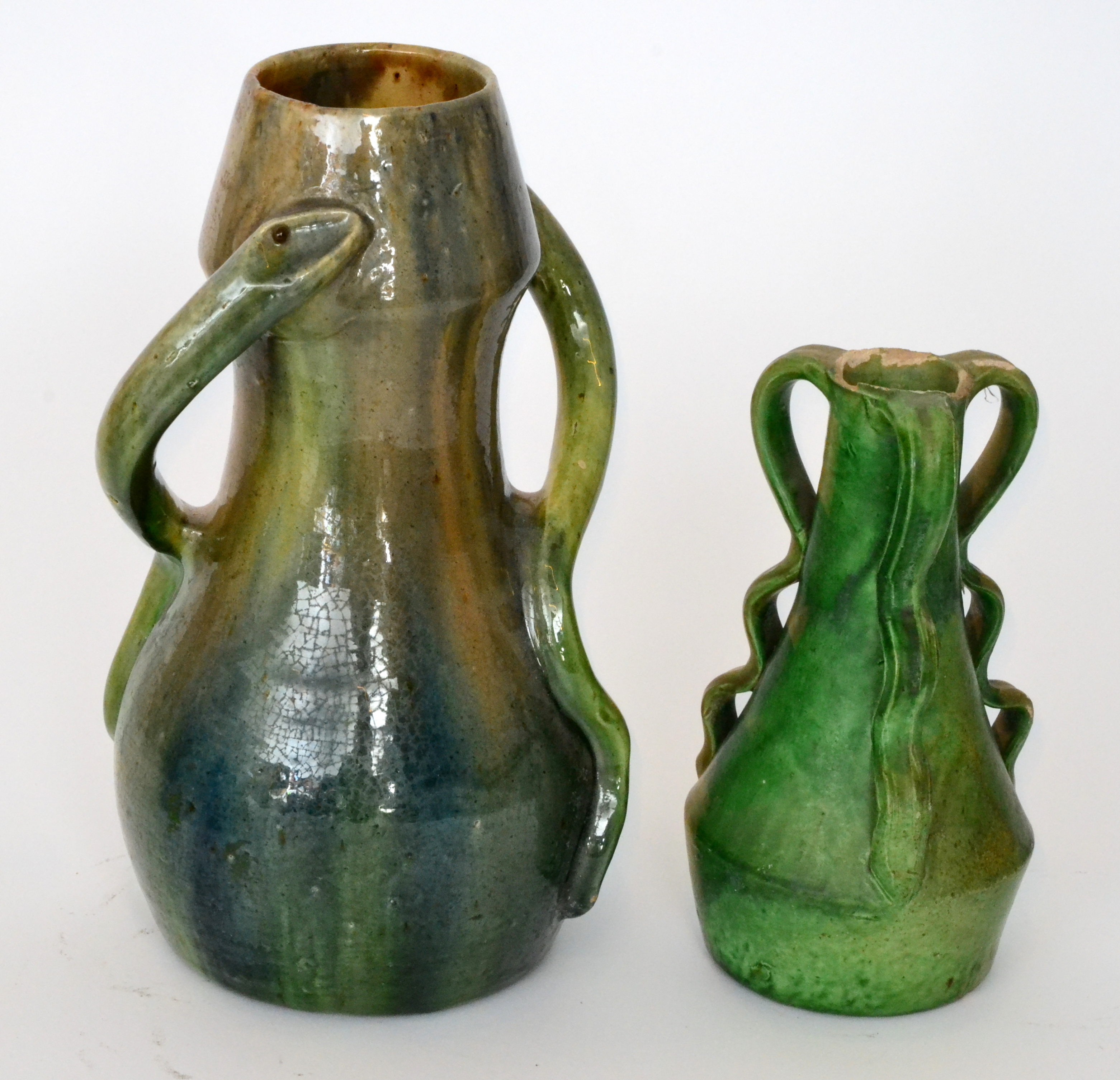 A late 19th Century pottery vase of skittle form decorated with two wrythen snake handles,