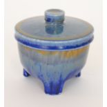 A Ruskin Pottery tri-footed vase and cover decorated in a tonal blue crystalline glaze,