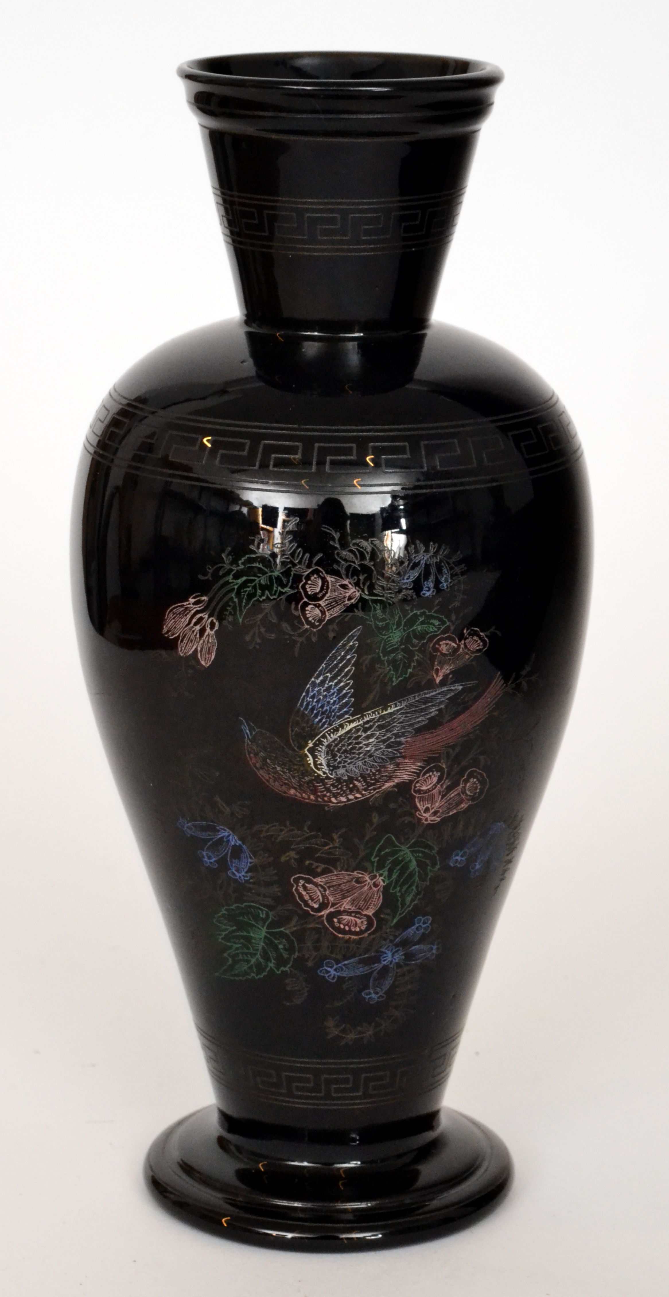 A late 19th Century black glass vase of footed shouldered ovoid form with flared collar neck,