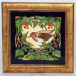 A Moorcroft Pottery plaque designed by Philip Gibson and decorated with a robin perched upon holly