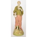 A large Royal Dux Bohemia figure of a lady dressed in green and soft red robes holding a carafe and
