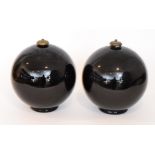 A pair of 1930s Belgian Art Deco glass lamp bases of footed spherical form in black glass with