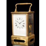 A late 19th to early 20th Century gilt and bevelled glazed cased striking carriage clock,