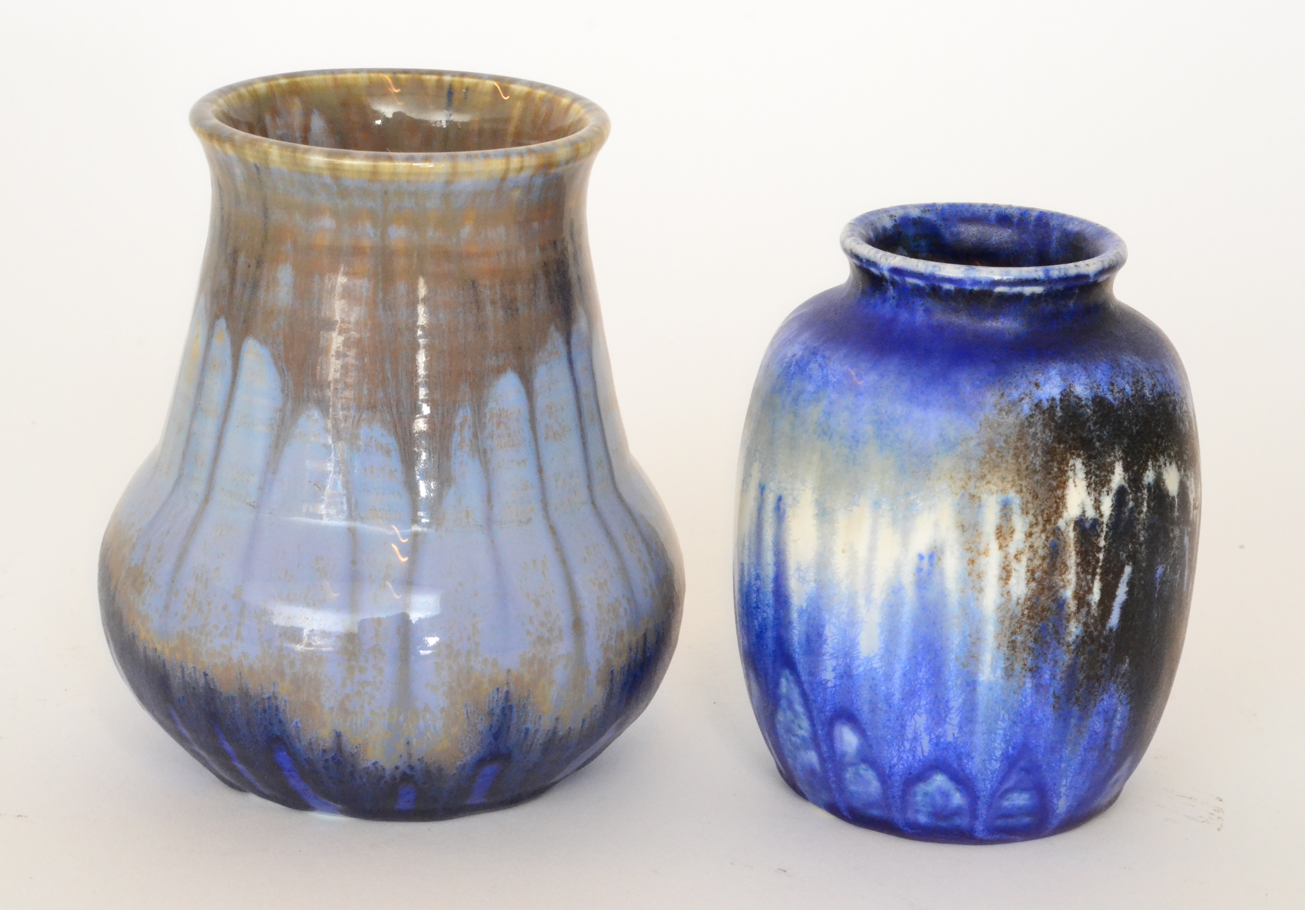 Two Ruskin Pottery vases, the first of globe and shaft form decorated in a streaked blue glaze,