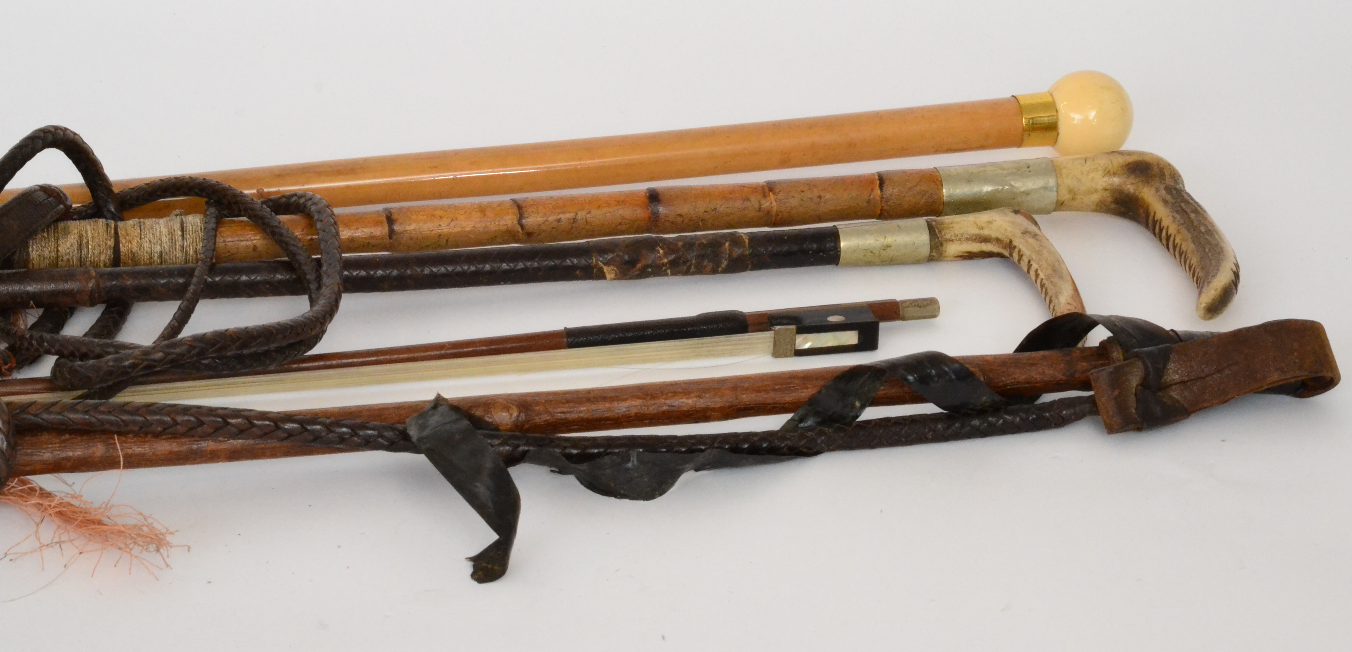 Three 19th Century horn handled leather riding crops together with an ivory ball shaped handle