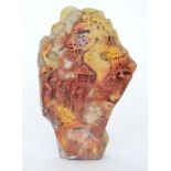 A late 20th Century Chinese carved shou shan red variegated soap stone depicting figures on a