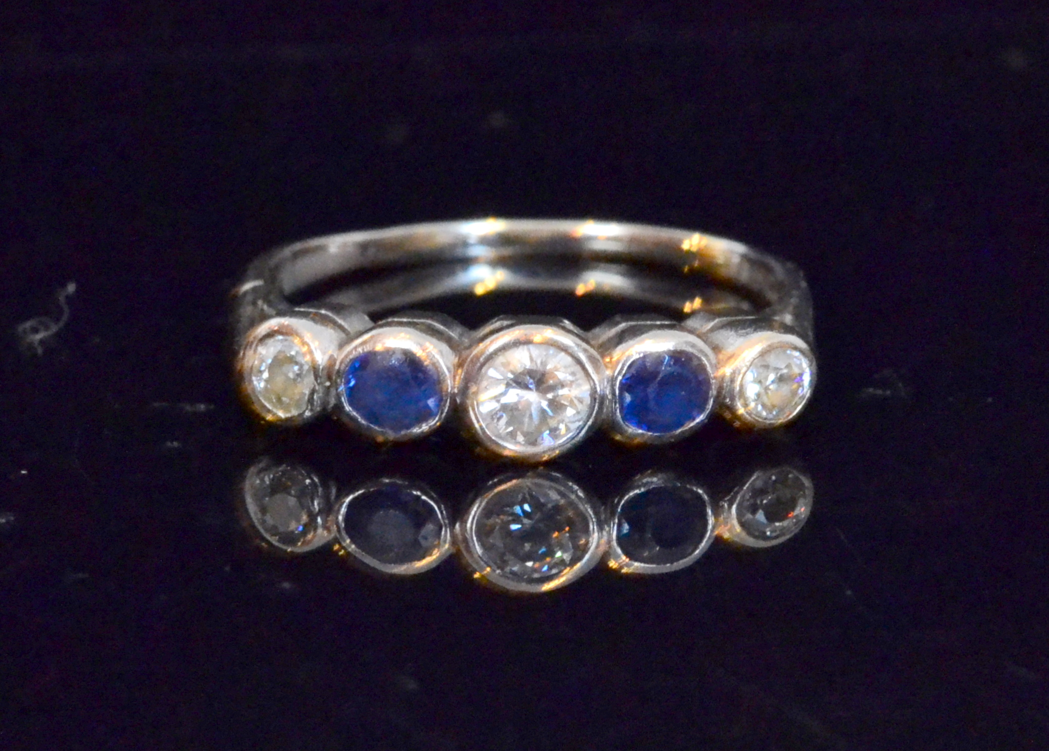 A sapphire and diamond five stone dress ring comprising alternating brilliant cut collet set stones