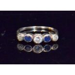 A sapphire and diamond five stone dress ring comprising alternating brilliant cut collet set stones