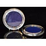 Two early 20th Century hallmarked silver circular photograph frames of plain form with blue velvet