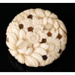 A late 19th to early 20th Century carved ivory netsuke in the form of a chrysanthemum flower head