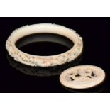 A late 19th to early 20th Century carved ivory bangle,