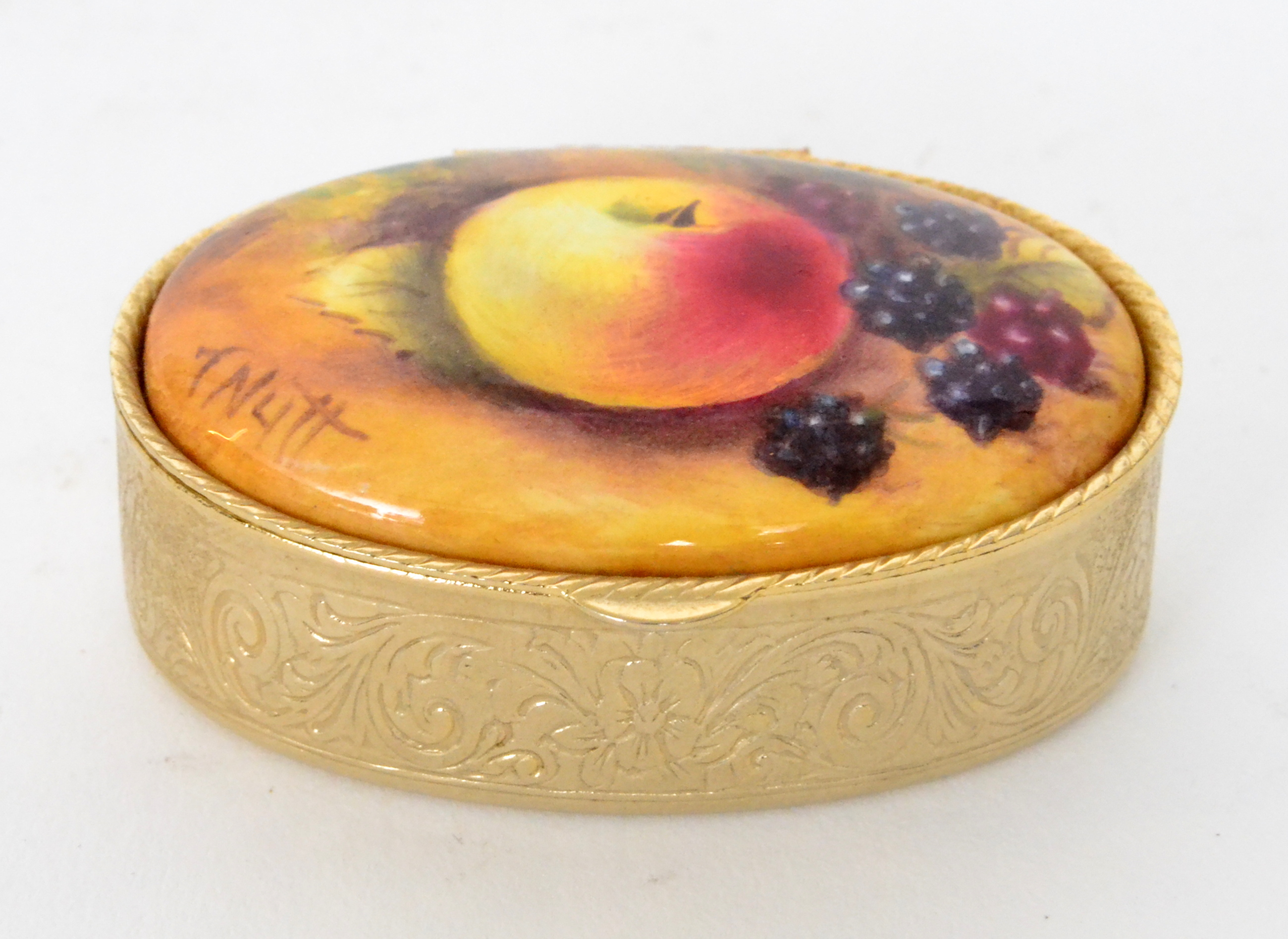 A contemporary oval pill box inset with a hand painted oval tablet depicting an apple and