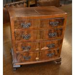 A miniature walnut apprentice chest of four long drawers, raised on ogee bracket feet,