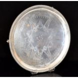 A Victorian hallmarked silver circular salver with bright cut garland and bow decoration within