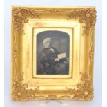 An early 19th Century ornately moulded gilt and gesso glazed picture frame containing a photograph