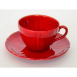 A Royal Doulton Flambe teacup and saucer decorated in a red glaze, printed marks,