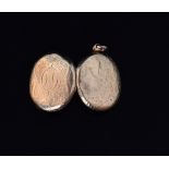 A Victorian yellow metal oval photograph locket, back and front engraved with foliate decoration,