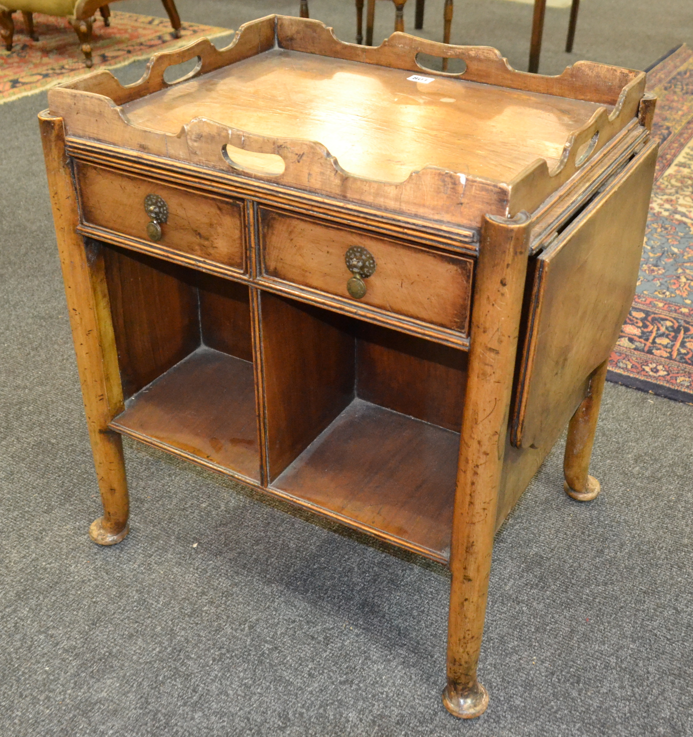 A 20th Century walnut drop flap tea trolley fitted with two drawers on pad feet,