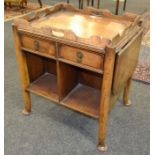 A 20th Century walnut drop flap tea trolley fitted with two drawers on pad feet,