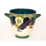 A large William Moorcroft twin handled footed jardiniere decorated in the Pansy pattern,