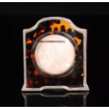 A George V hallmarked silver mounted tortoiseshell picture frame of shaped rectangular outline and