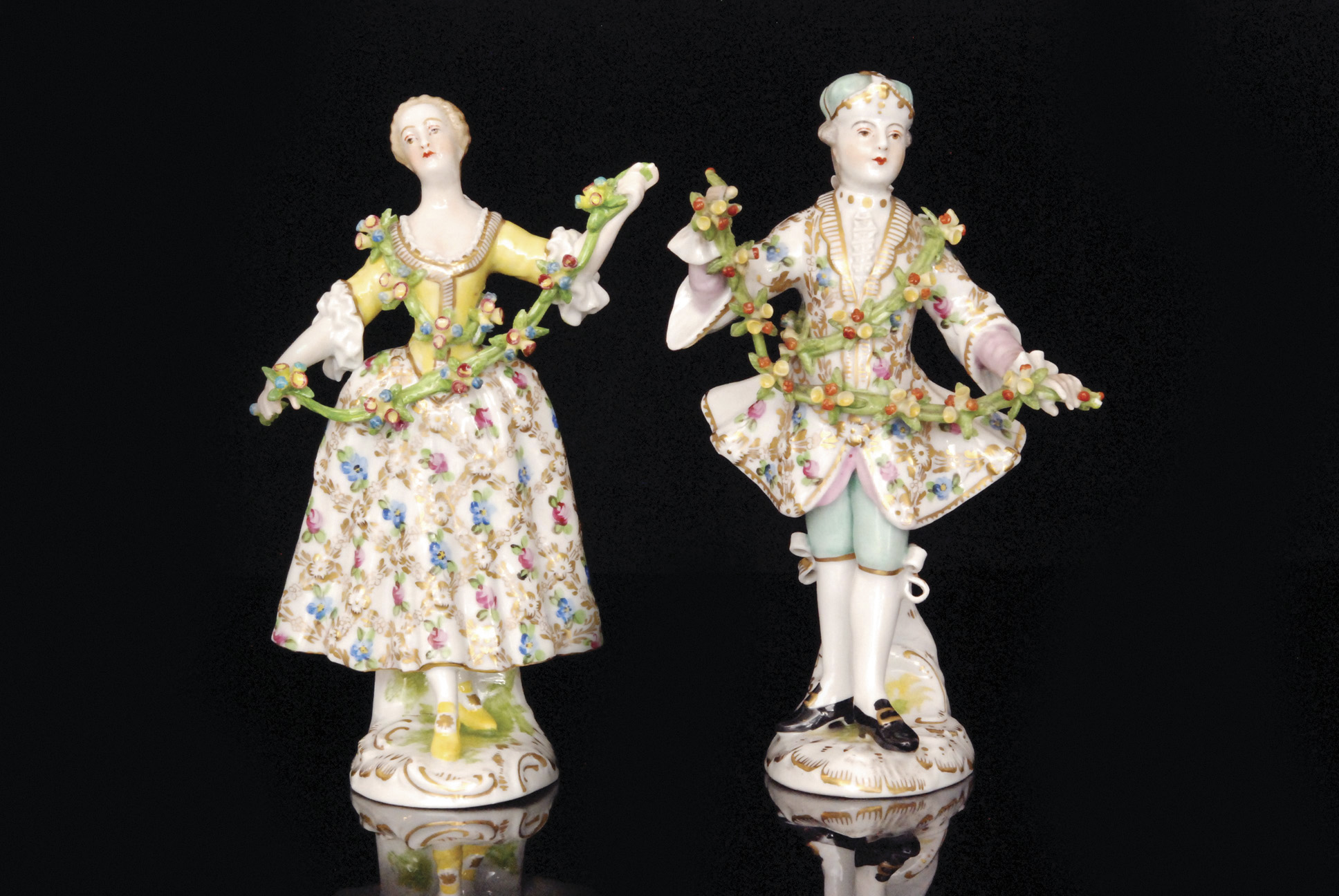 A pair of 19th Century Dresden figurines modelled as a young lady and her male companion,