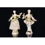 A pair of 19th Century Dresden figurines modelled as a young lady and her male companion,